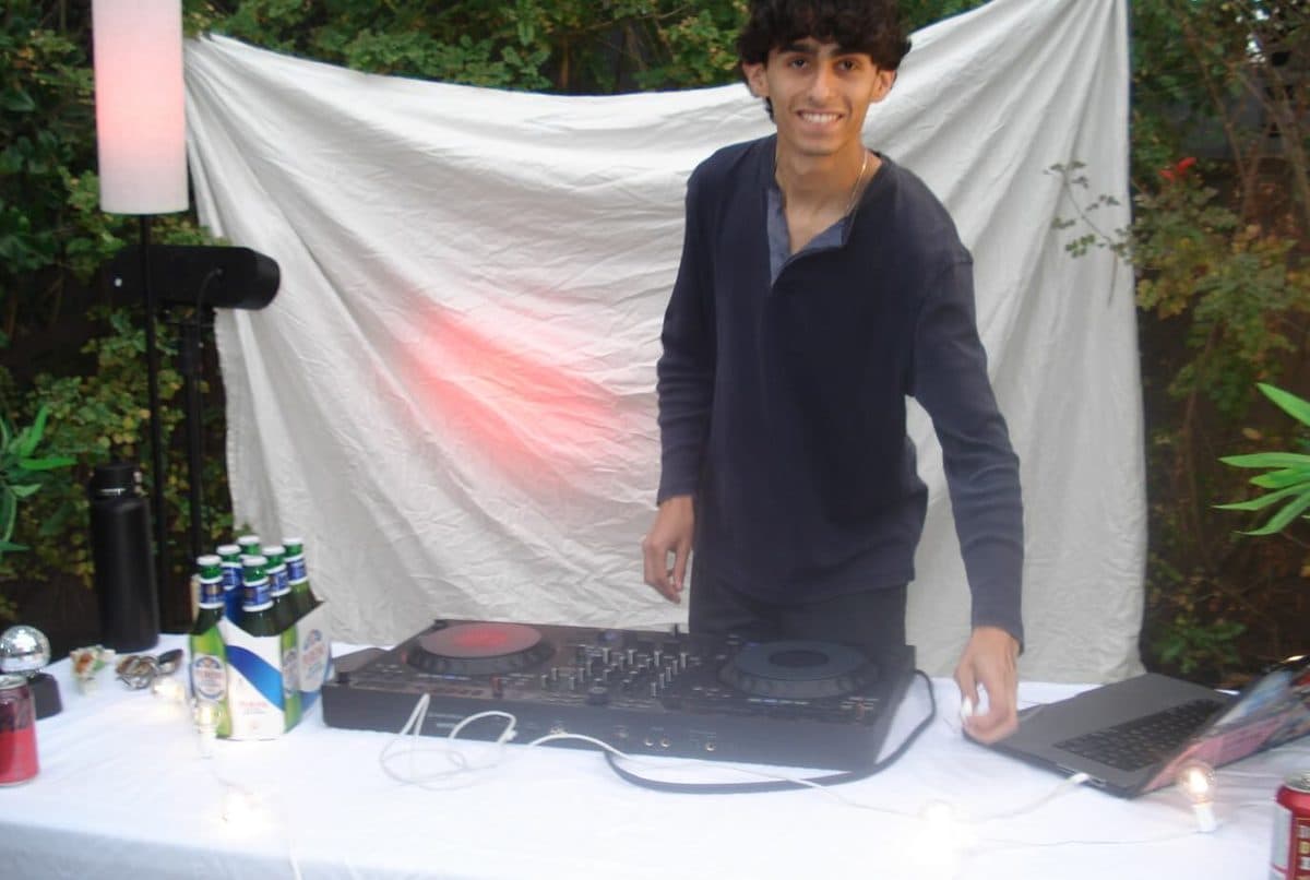 A DJ smiling behind the decks at the first Palm Radio show in Los Angeles